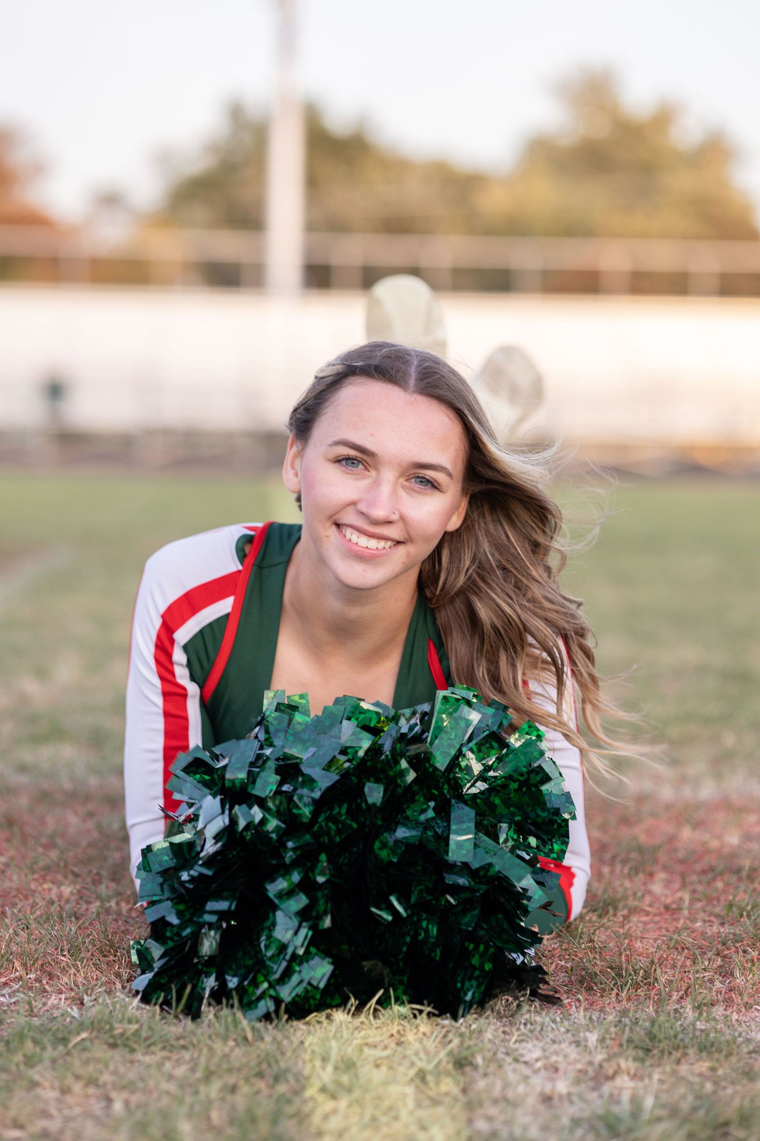 Springfield, IL senior photographer captures a senior with her cheer poms on a football field during a session in Central, IL