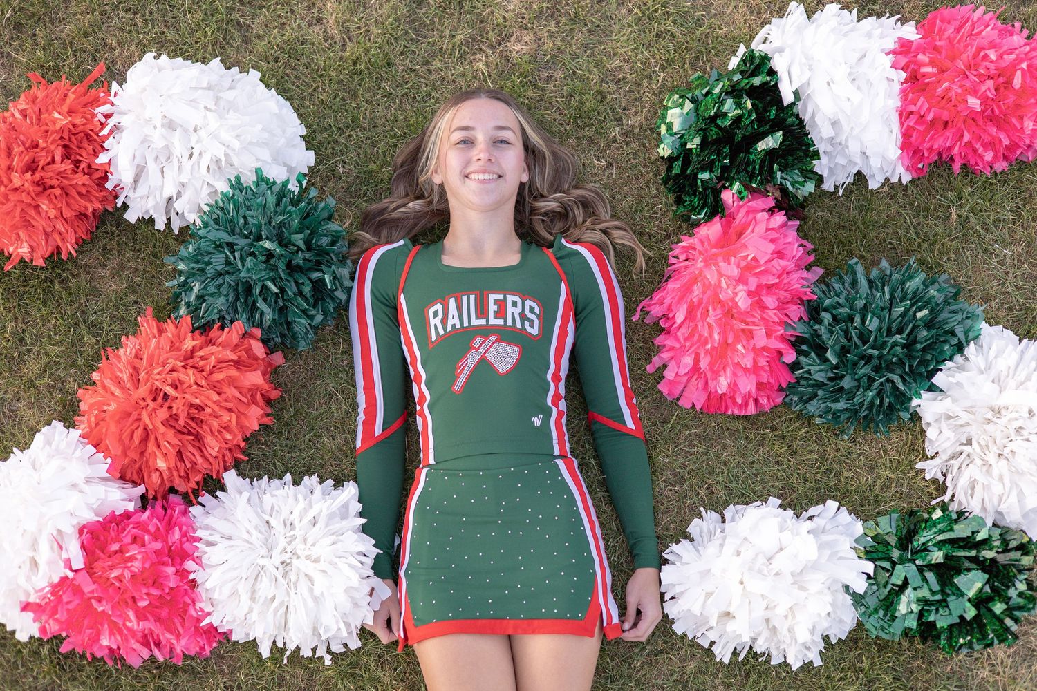 Springfield, IL senior photographer captures a senior on the ground with her cheer poms making a "25" during a session in Central, IL