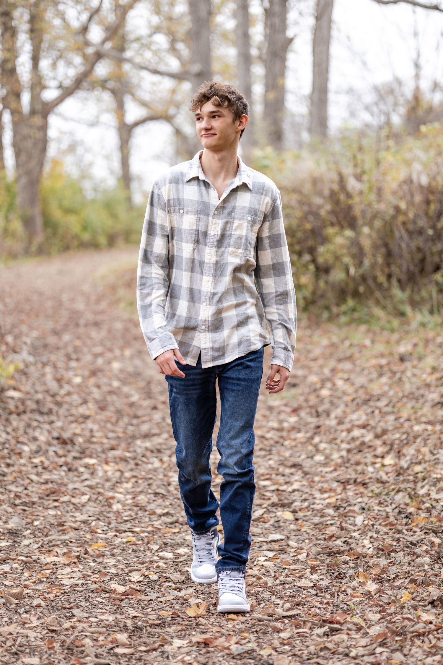 Springfield, IL senior photographer captures a senior walking on a trail during a session in Central, IL