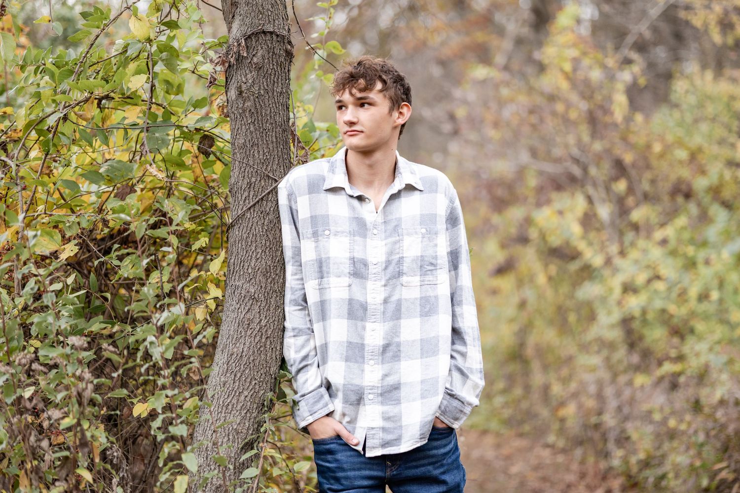 Springfield, IL senior photographer captures a senior leaning on a tree during a session in Central, IL