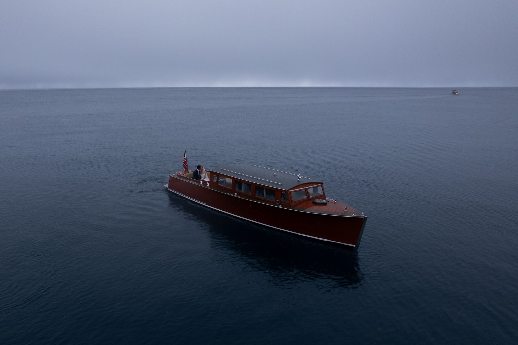 A series of photographs showing a wooden speedboat cruising across calm waters at sunset on a serene lake.