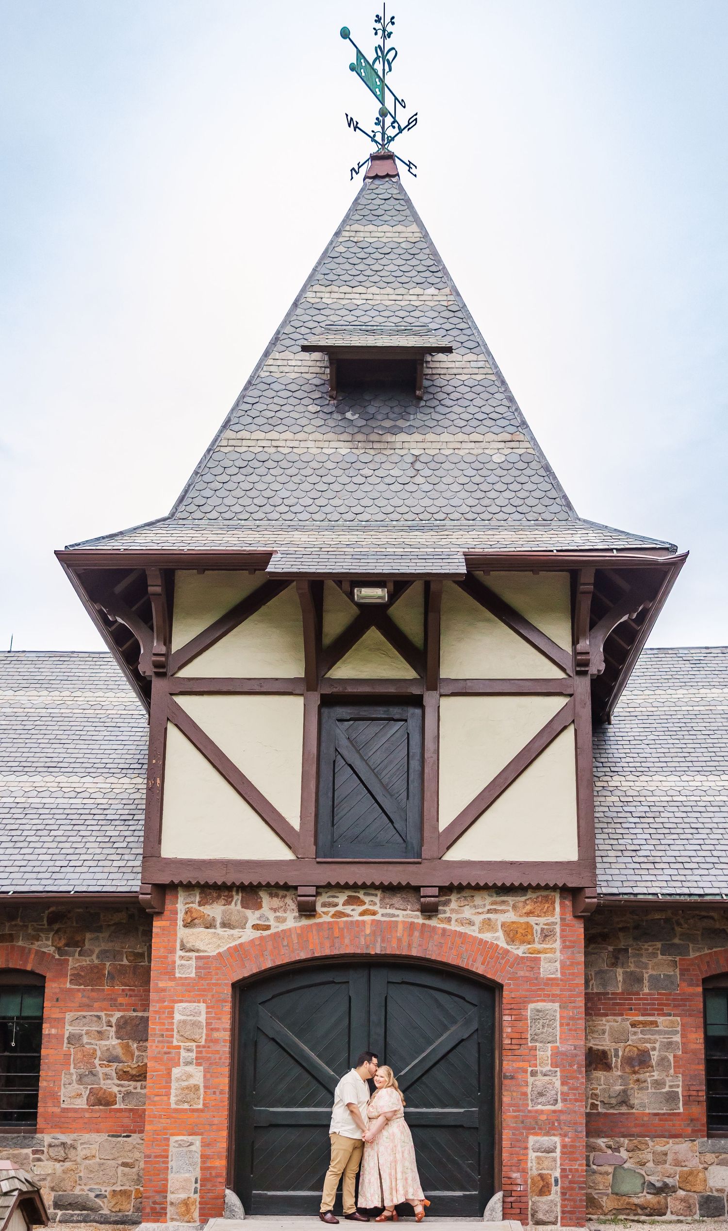 A close-up view of gothic-style brick architecture with pointed gables and decorative trim details against a light sky.