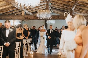 Elegant indoor wedding ceremony with wooden beams, crystal chandelier, and guests at Grand Lodge Oaklands - taken by Grimsby photographer.