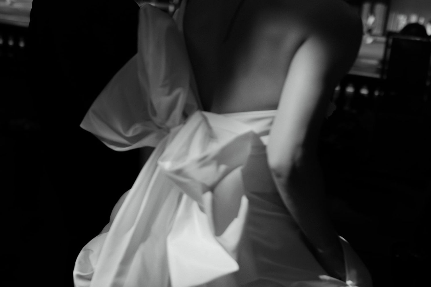 Close-up black and white detail of structured wedding dress fabric and bow.