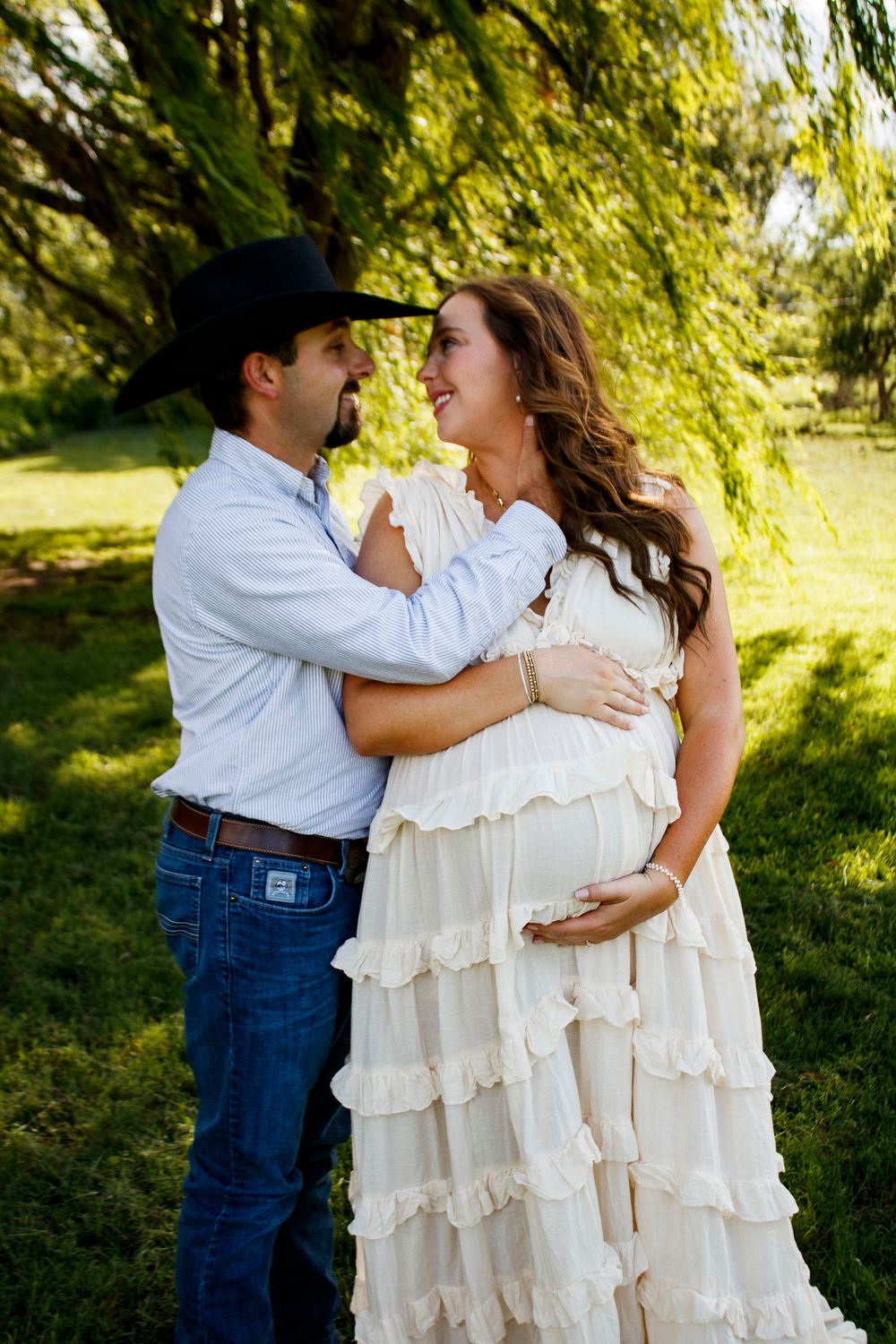 An expecting couple during a maternity photo session at Willow Tree Park in Canyon, Texas