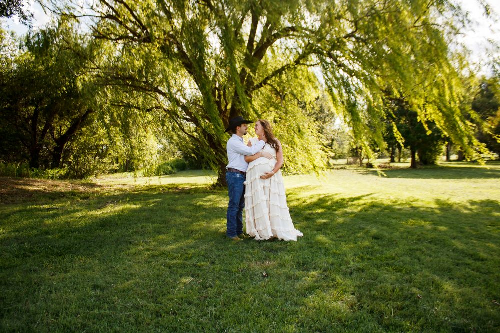 An expecting couple during a maternity photo session at Willow Tree Park in Canyon, Texas