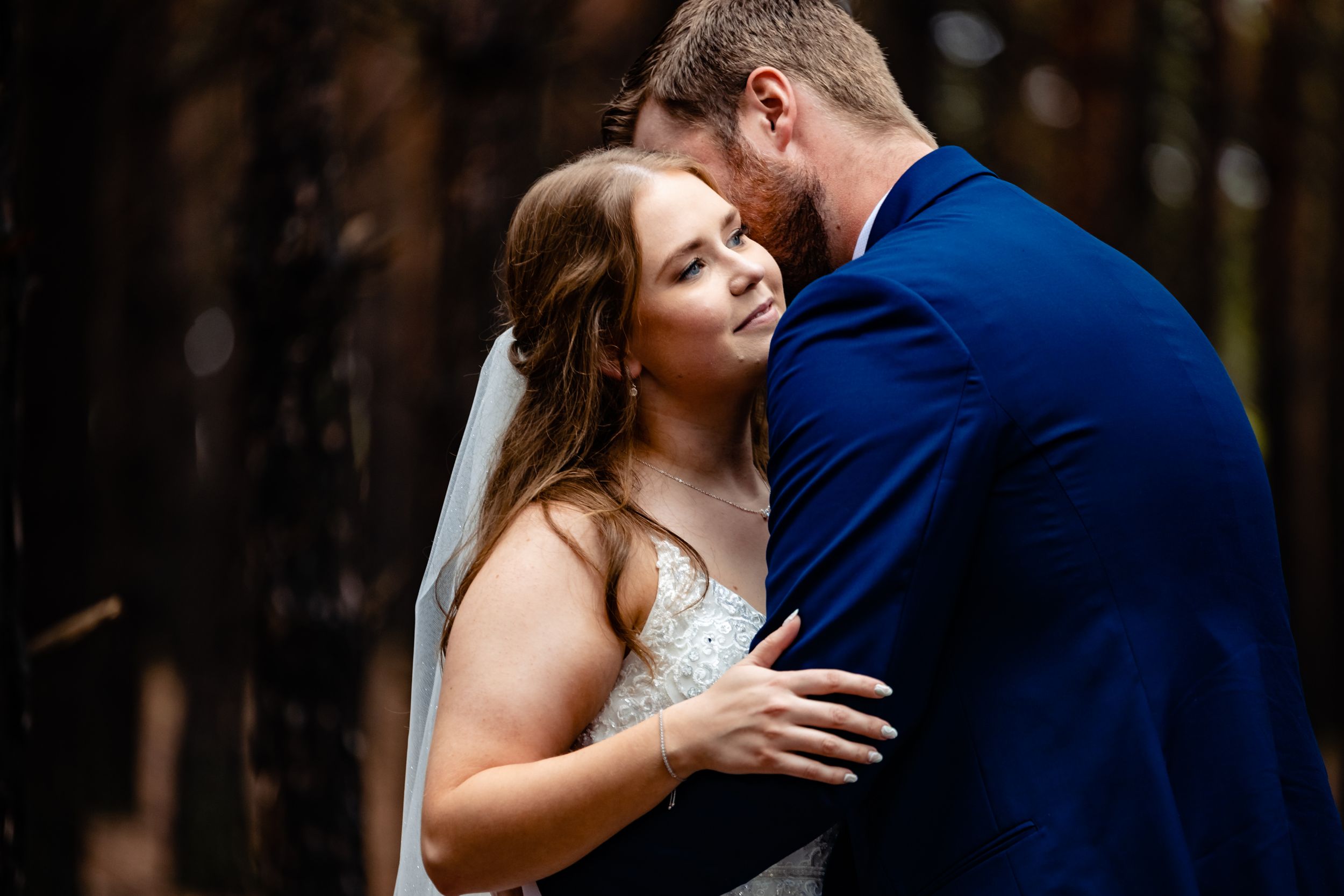 Intimate first look moment at a wedding ceremony with a pair in a navy suit and white dress.