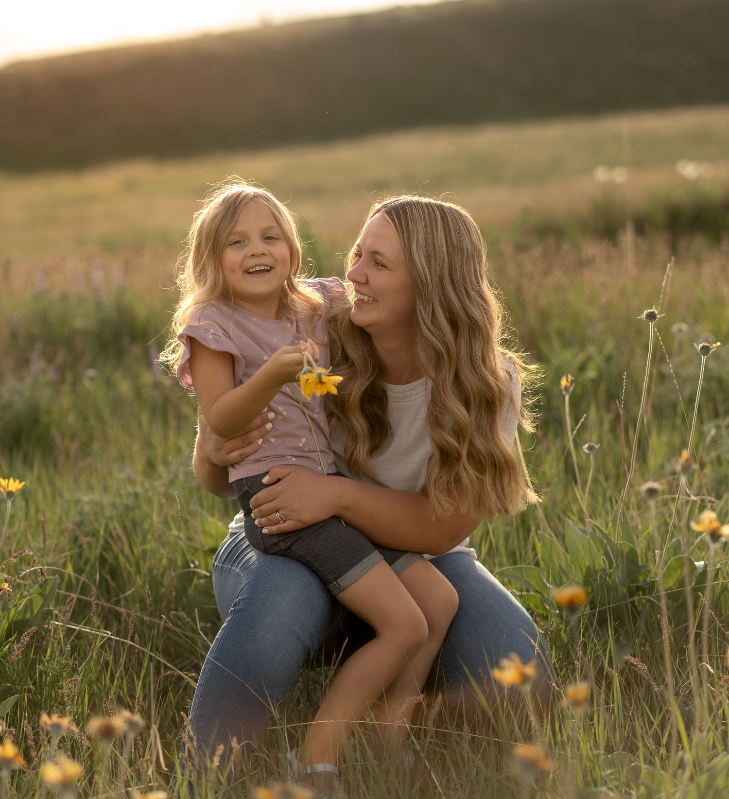 Joyful mom embracing her children in a beautiful outdoor family photo session in Logan, UT. Done during a golden hour light.