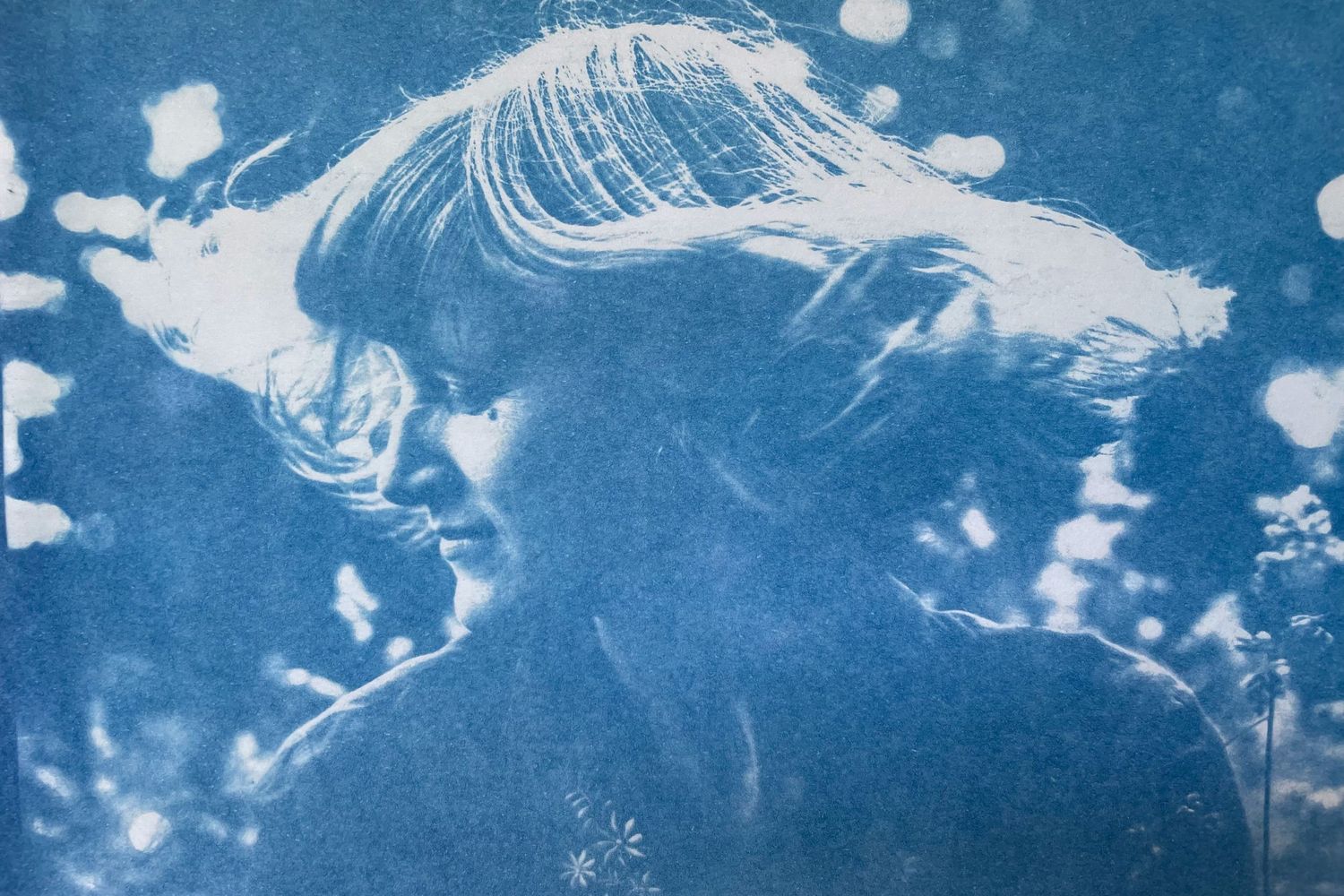 A series of bright blue cyanotype photographic prints showing abstract patterns on paper.