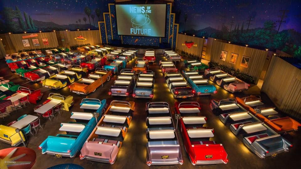 Retro-styled dining room with rows of car-themed booth seating under dim lighting.