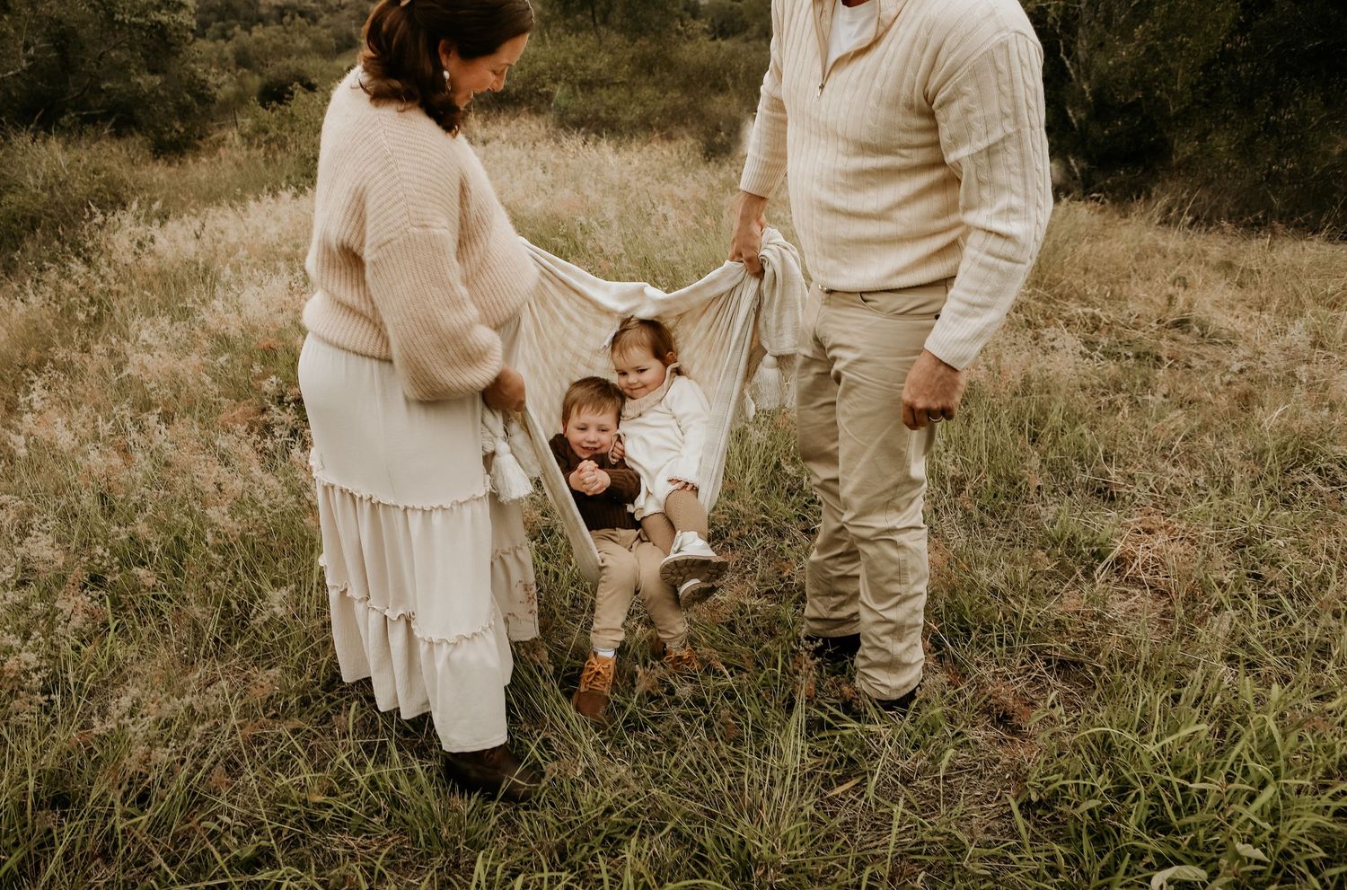 Siblings sitting in a blanket swing during photo session