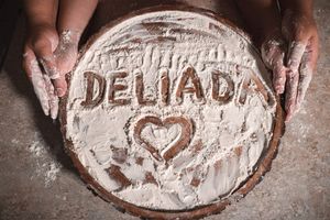 Decorative text written in flour on a dark baking surface.