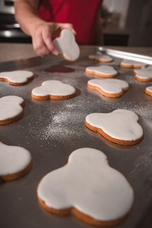 White frosted cookies arranged on a dark baking sheet.