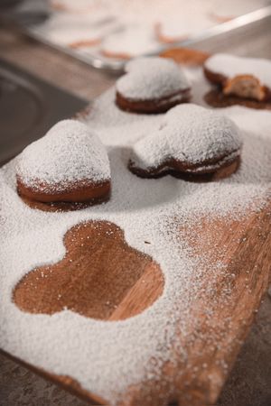 Close-up of powdered sugar dusted over chocolate cookies creating a decorative pattern.