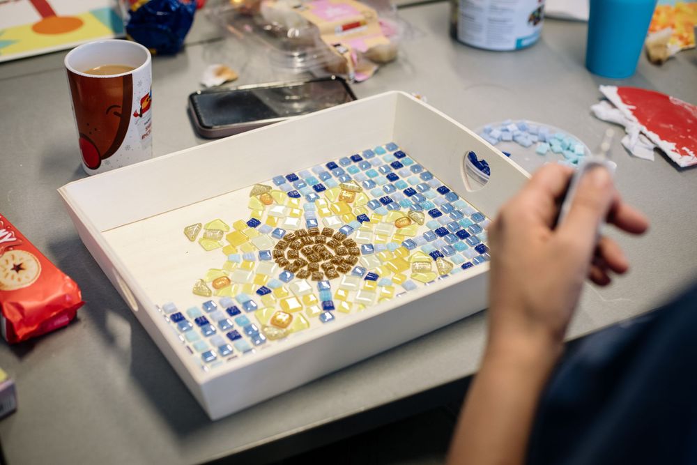 Multiple images show the process of creating decorative artwork using paint and splatter techniques on a flat surface.