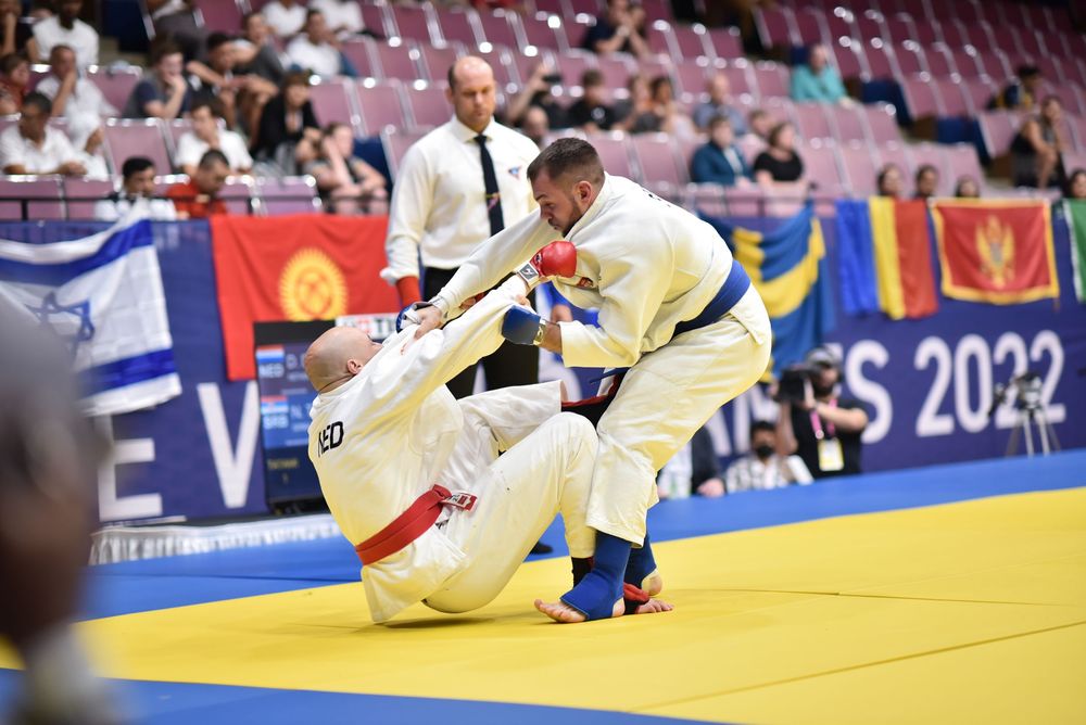 Two judokas compete on the mat at the 2022 European Judo Championships in a white gi match.