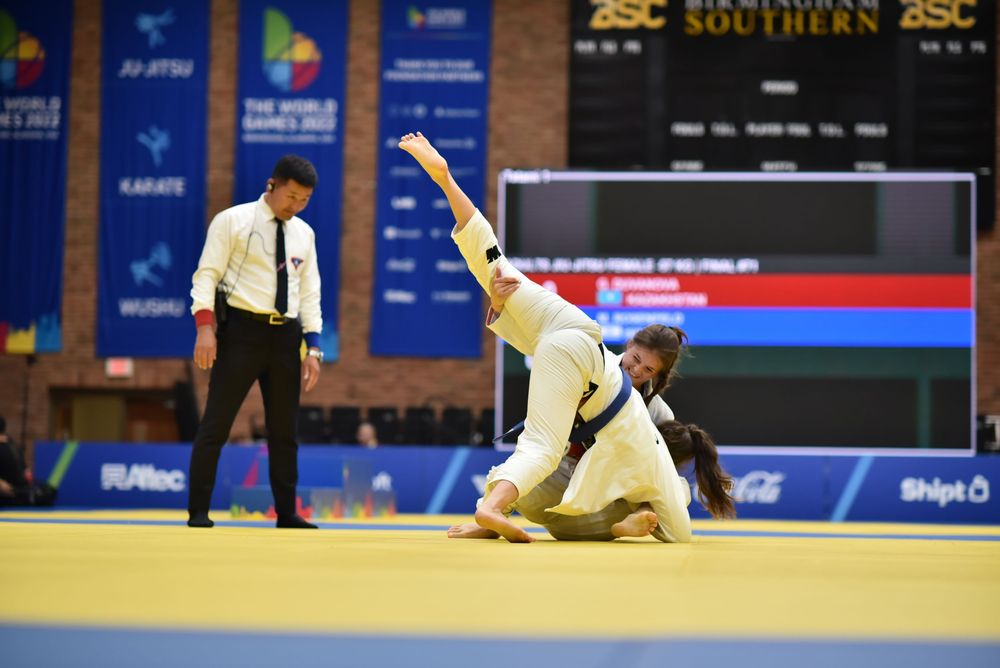 Two judo athletes compete on a yellow mat at the 2022 World Games in Birmingham, Alabama.