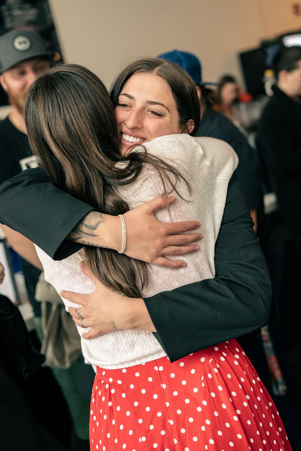 women hugging at a corporate event and being photographed by professional photographer