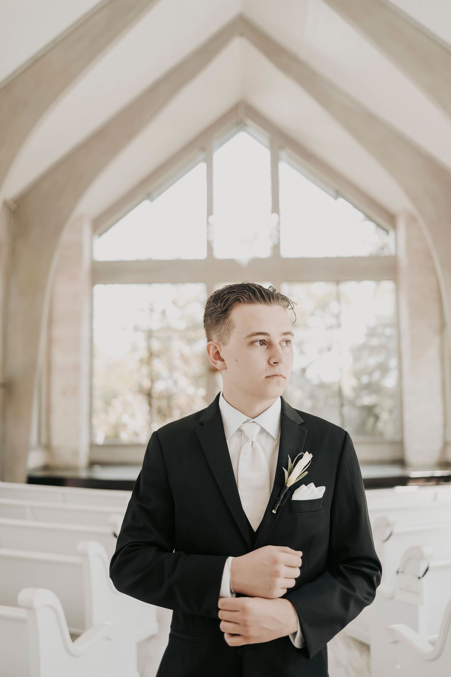 Black tie groom portraits inside Brighton Abbey chapel