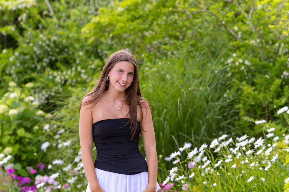 High school senior poses by flowers in Chatham on Cape Cod for her senior yearbook portrait photos.  High school senior photographer.