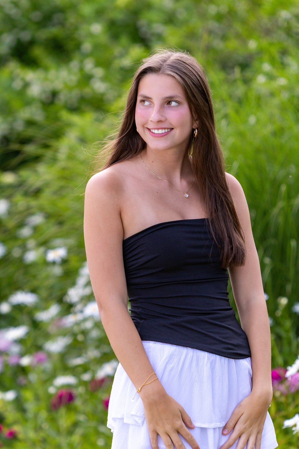 High school senior poses by flowers in Chatham on Cape Cod for her senior yearbook portrait photos.  High school senior photographer.