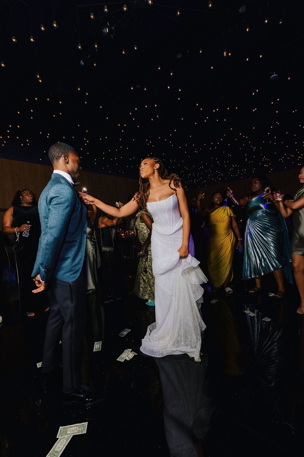 Bride and groom share first dance under starlit ceiling lights at elegant wedding reception.
