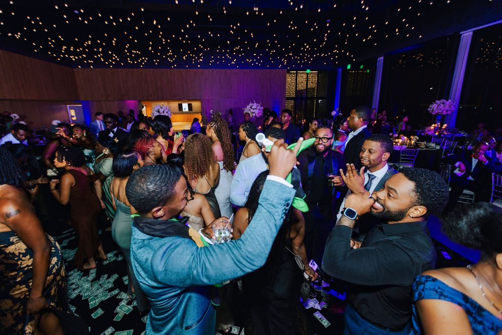 Guests dancing and celebrating at an elegant evening gala event with twinkling star ceiling lights.