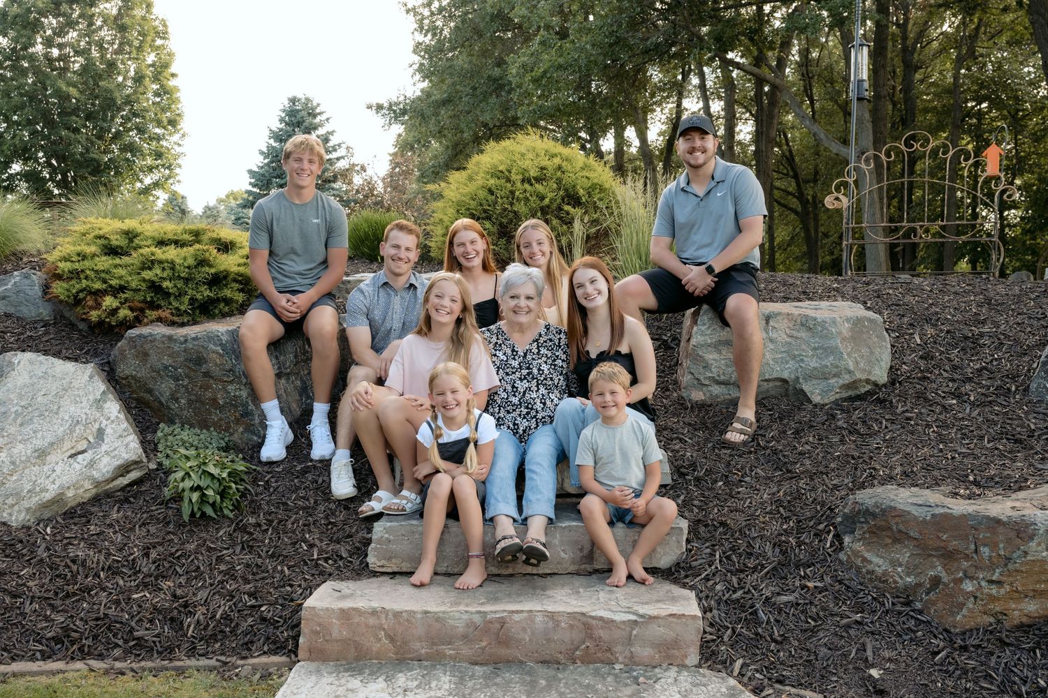 all grandkids snuggle around grandma for extended family summer portraits at the cabin on lake wissota in chippewa falls, wi
