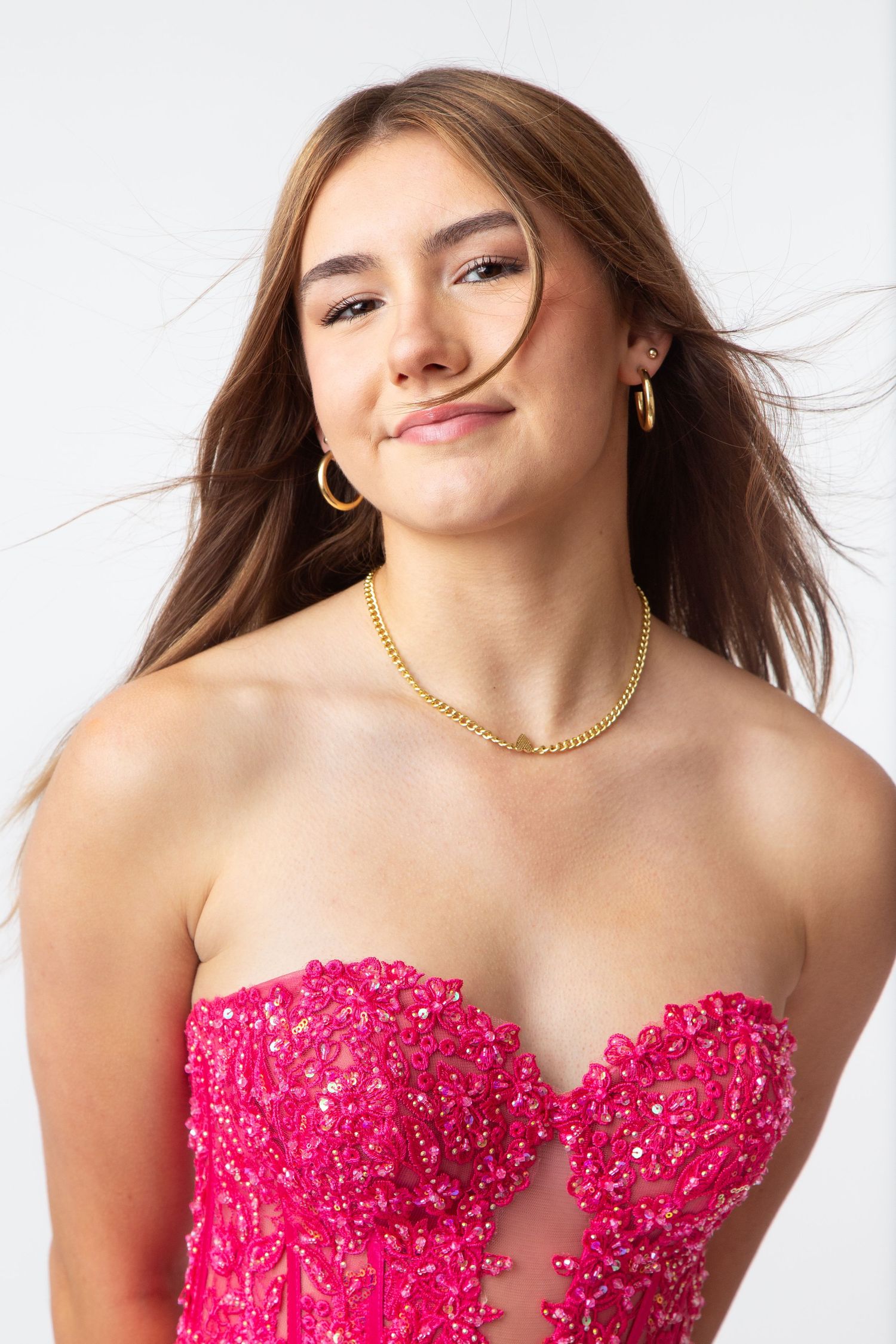 Photo of a high school senior in a gold sequin prom dress and matching butterfly earrings at Celebrations Bridal and Prom New Braunfels TX
