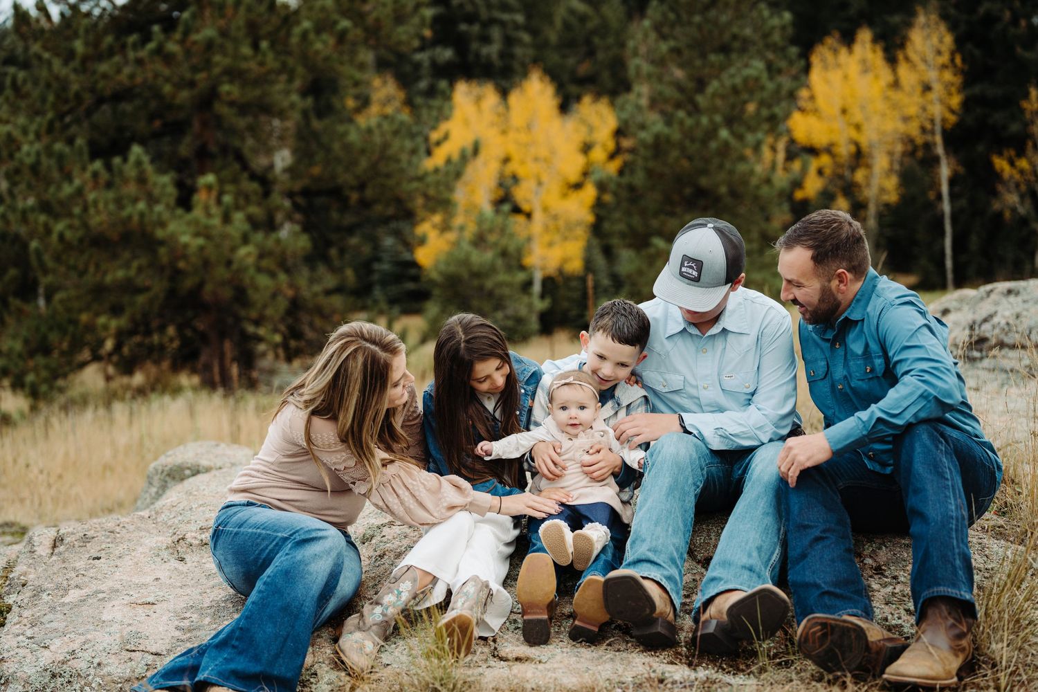 a family cuddles amid aspens and rocks during a photography session in Colorado