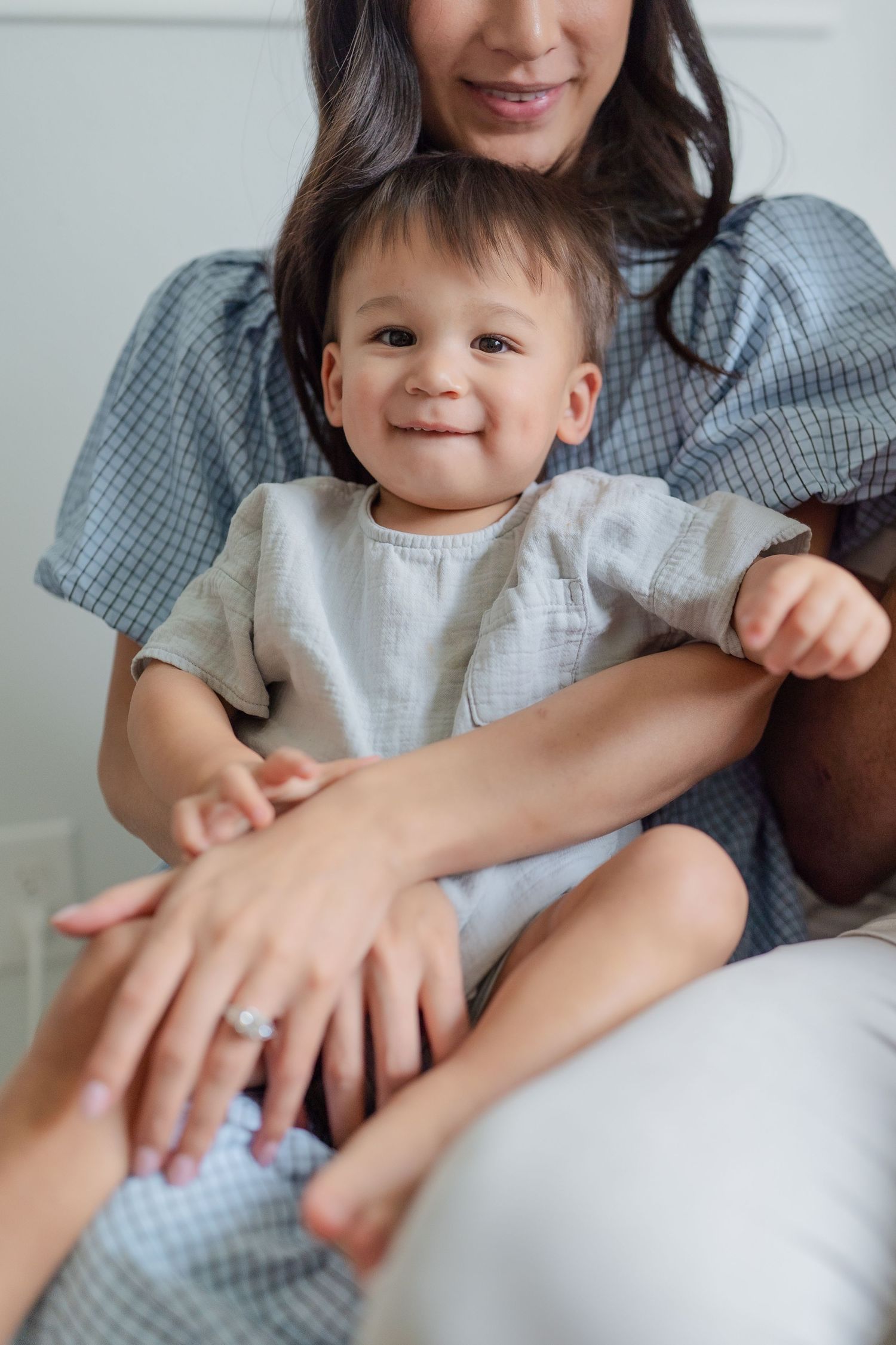 Mom wearing baby blue dress holding toddler in while sitting on chair