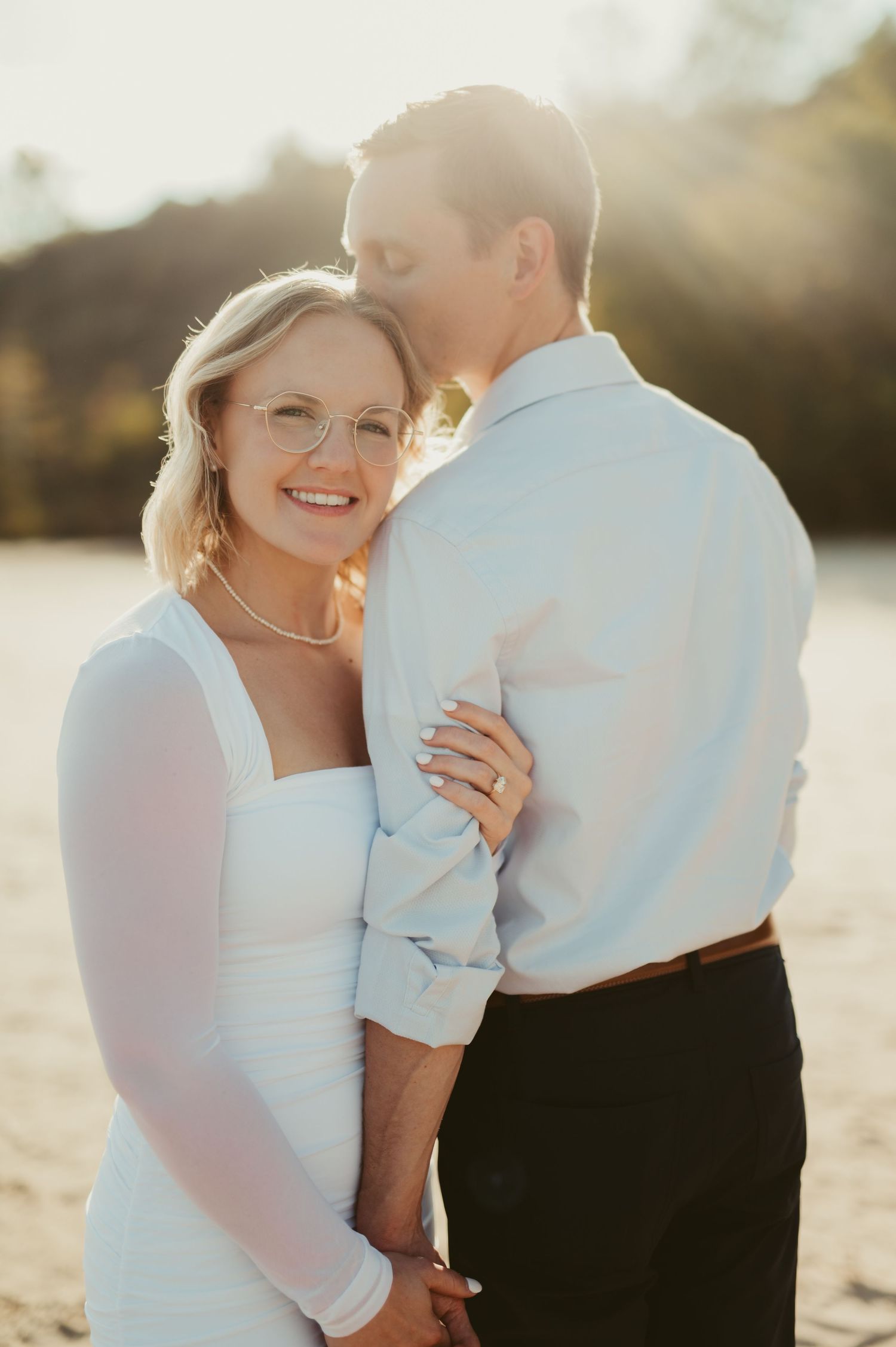 Couple embracing on a beach at golden hour during an elopement in Port Washington, Wisconsin.