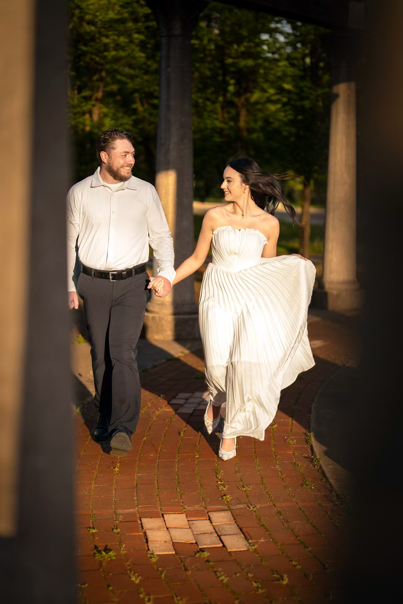 A joyful couple holds hands and walks together outdoors, Franklin Park for Engagement Photo
