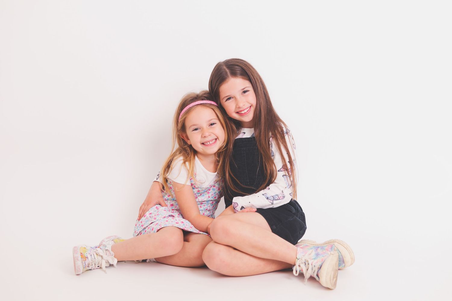 Studio portrait of children sitting together against white background.