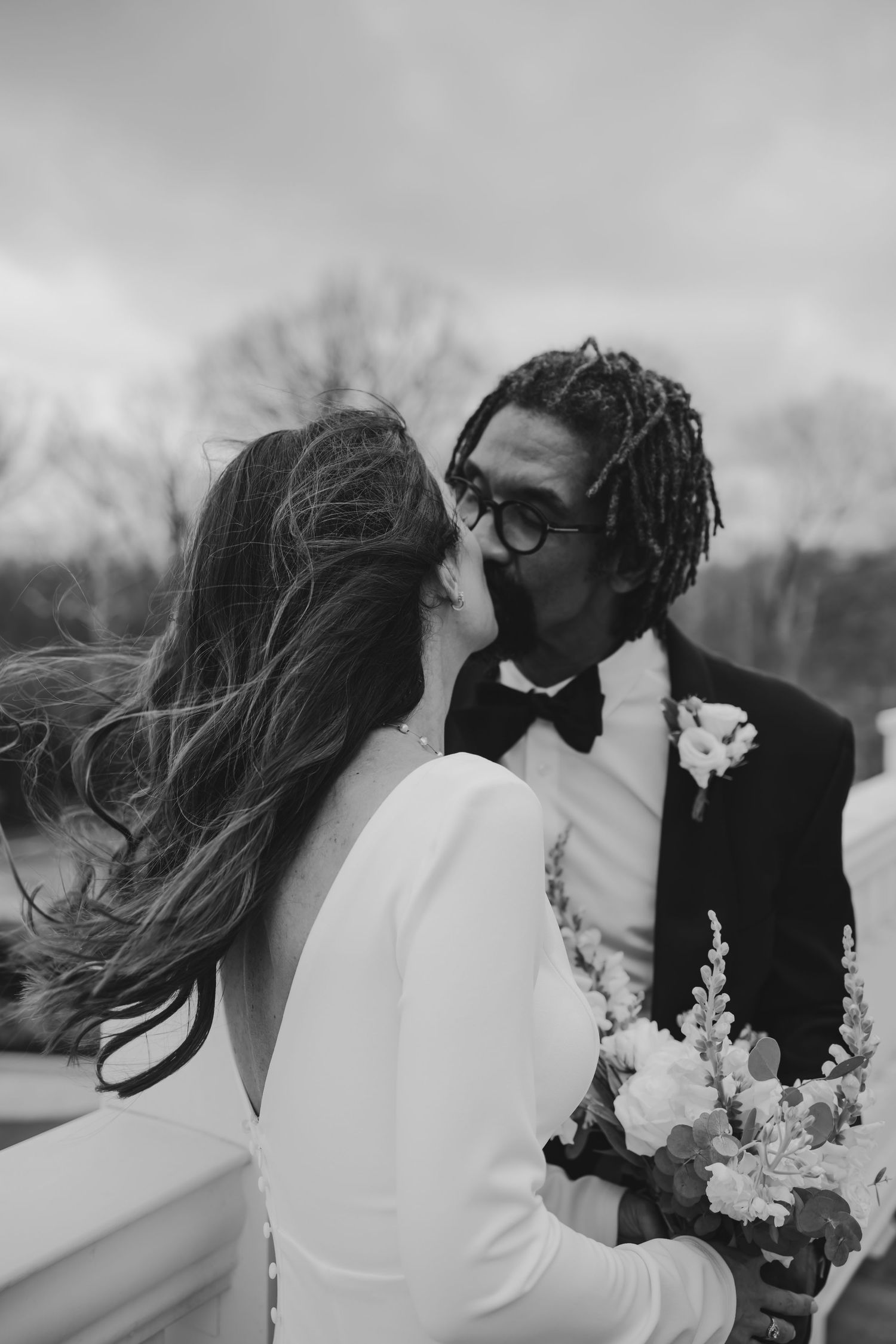 Bride and groom, wedding portrait kissing on a windy day at Holliday Farms in Zionsville, Indiana