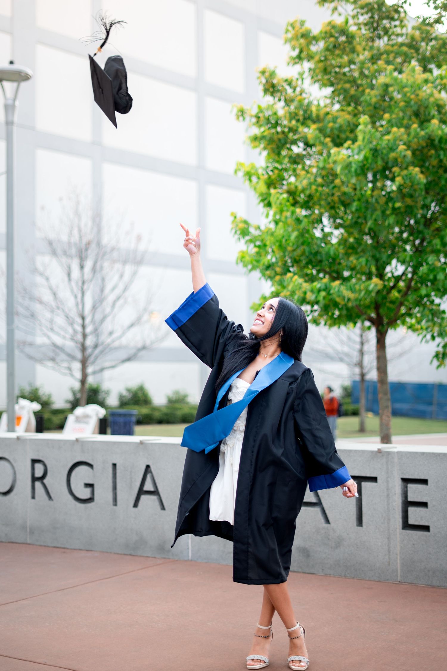 Smiling graduate poses for the best Atlanta grad photos at Georgia State University with portraits by Pierre The Pear Photography