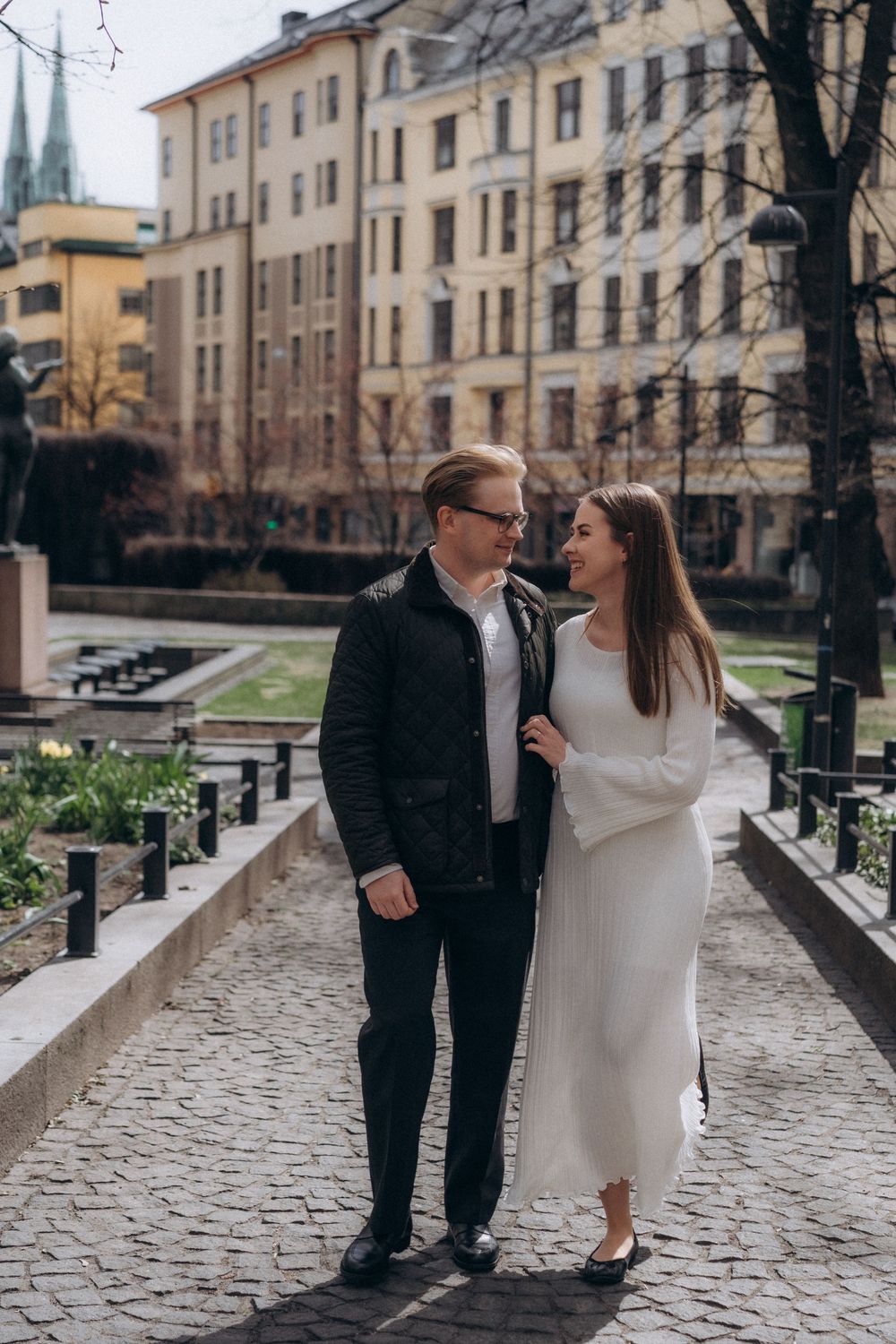 Editorial engagement portrait of a couple standing together by the water in Helsinki city centre