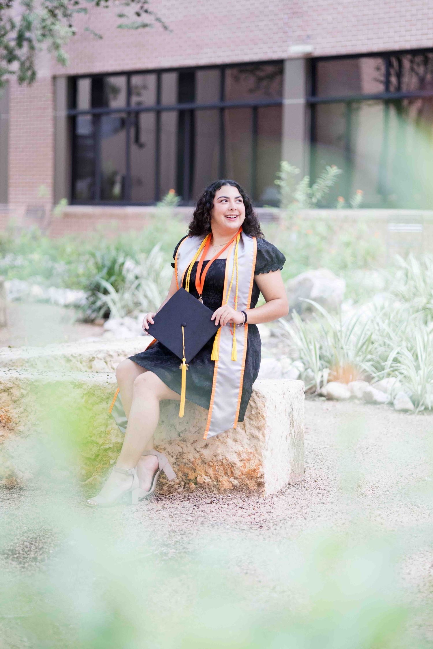College graduate enjoying a candid moment during their graduation session in Holly Springs, NC, surrounded by nature