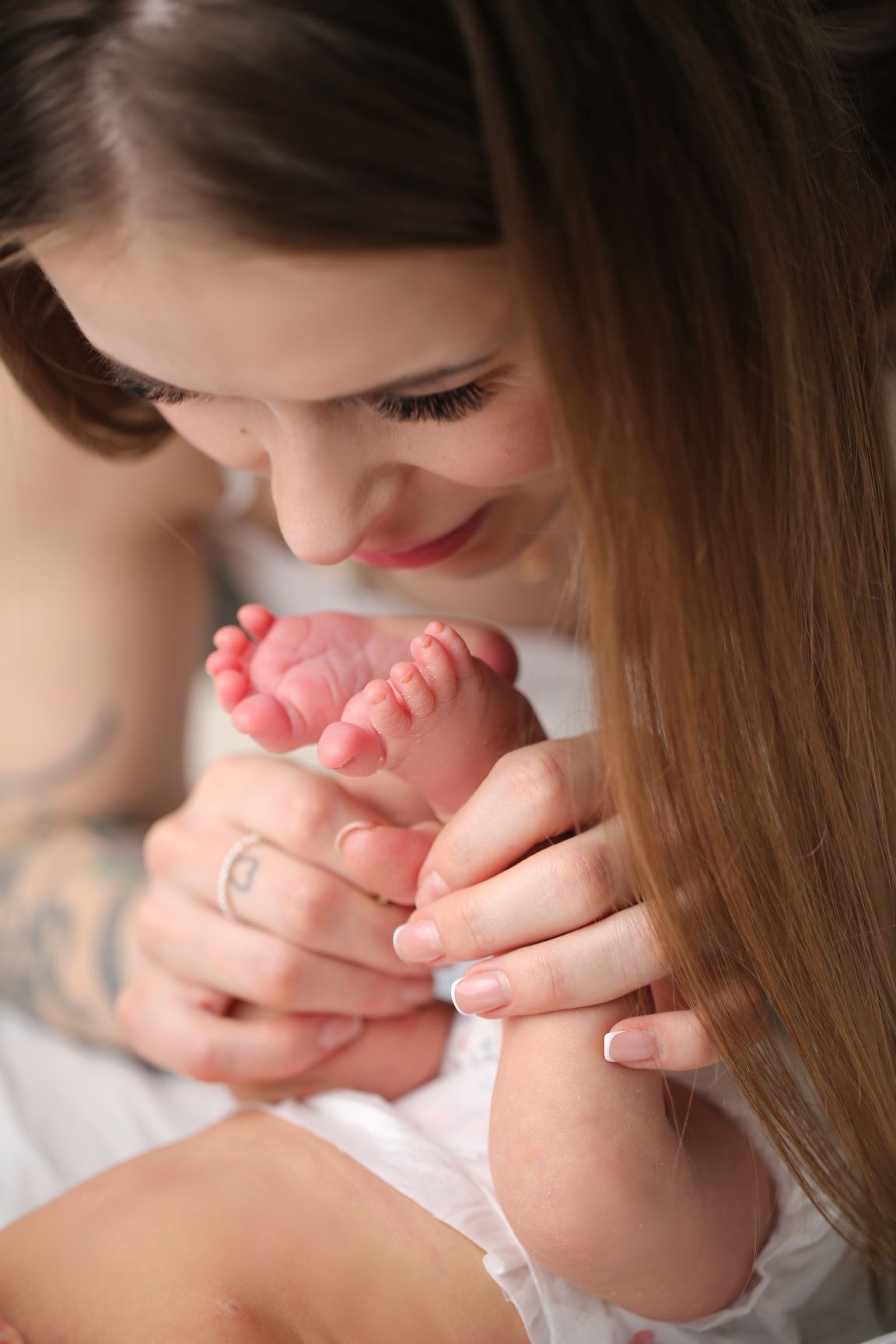 Close-up of tender moment with tiny baby feet being held.
