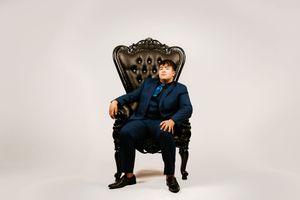 A figure sits in a black chair against a white studio background in multiple segmented poses.