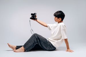Several minimalist photos show someone in a white t-shirt and dark pants positioned in different reclining poses on gray background.