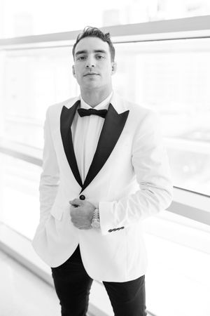 A formal black and white tuxedo ensemble featuring a white dinner jacket and black bow tie.