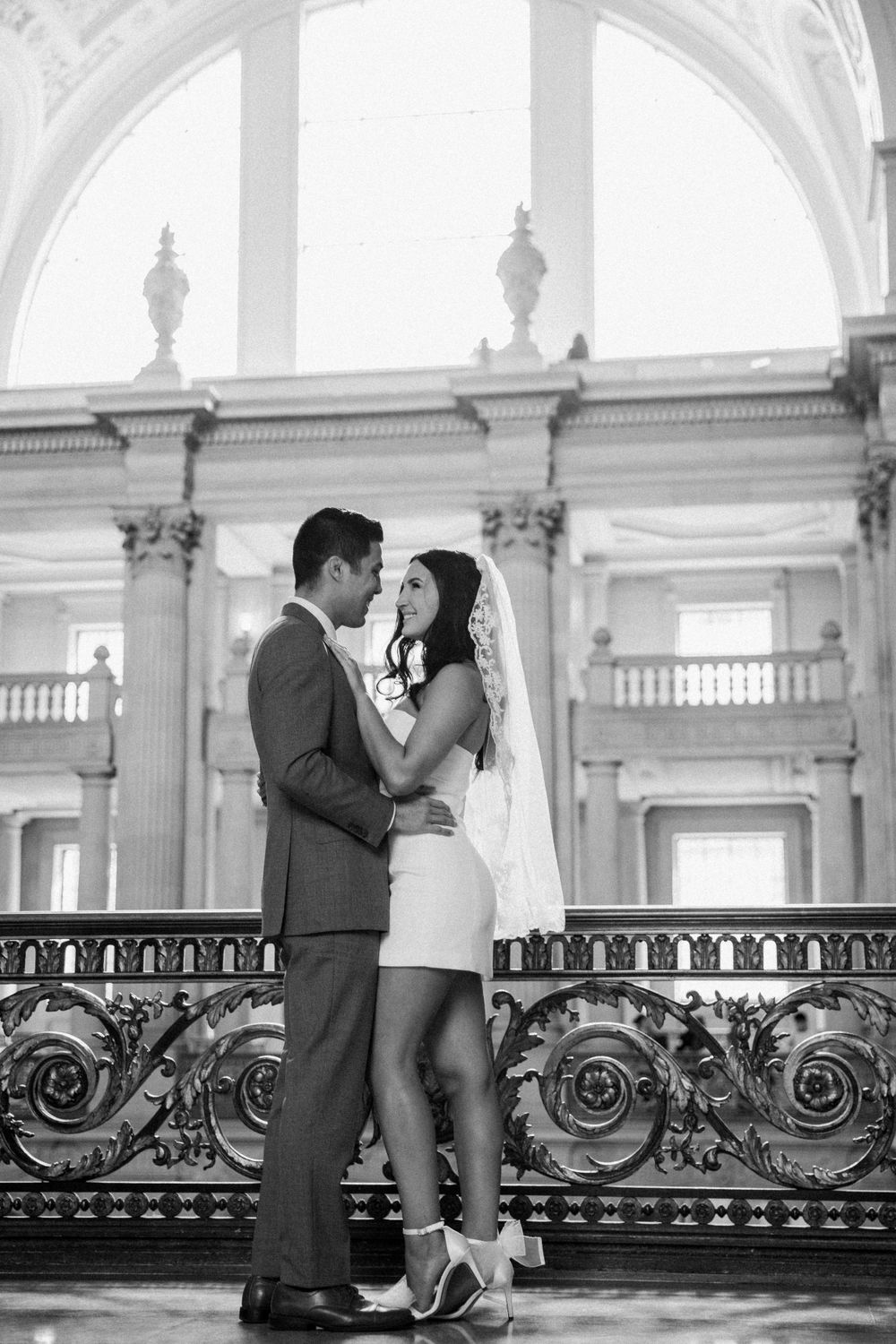 Asian groom and caucasian bride smile after eloping in San Francisco City Hall.