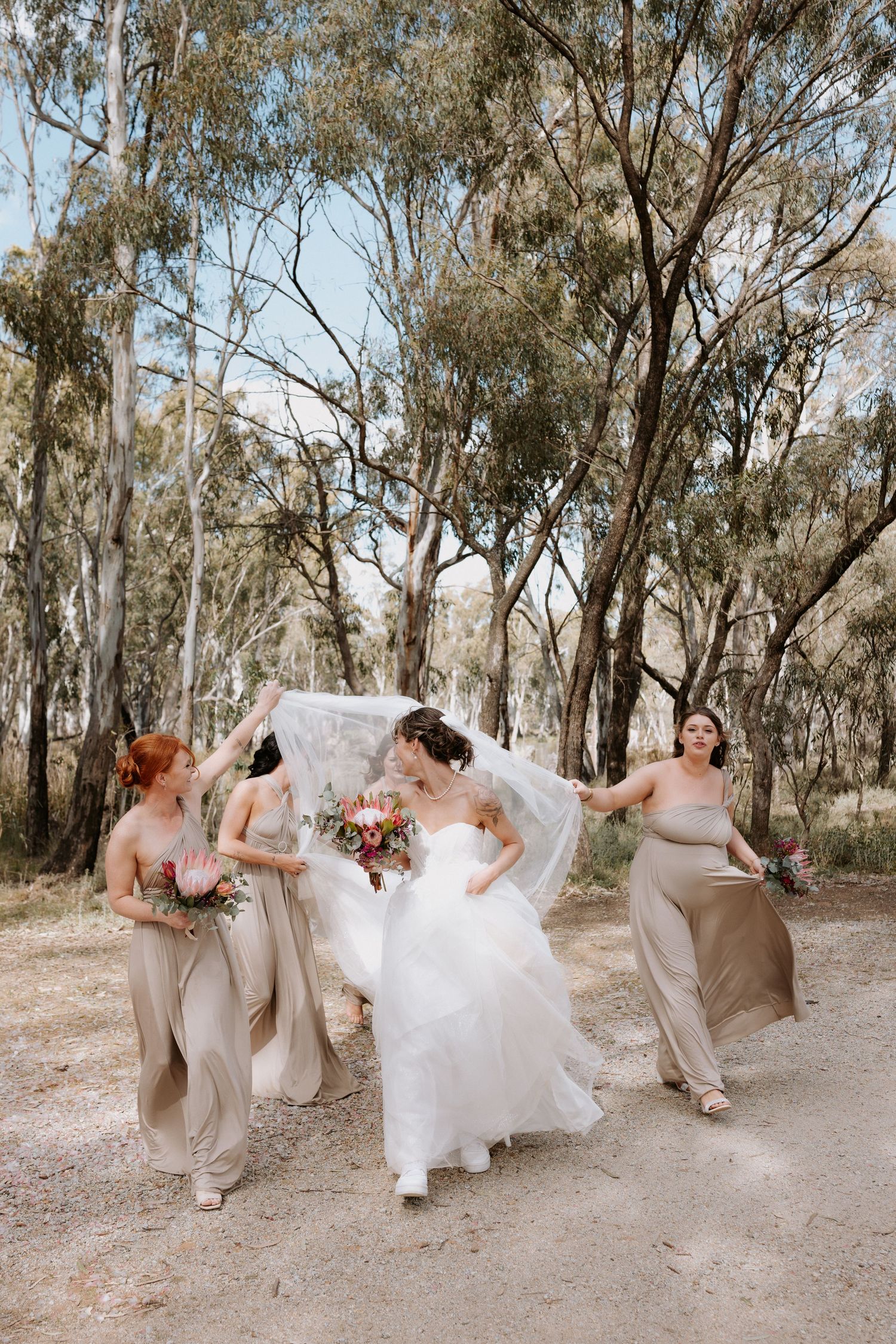 A fun wedding party sequence showing playful dance moves and twirls in a rustic outdoor setting with eucalyptus trees.
