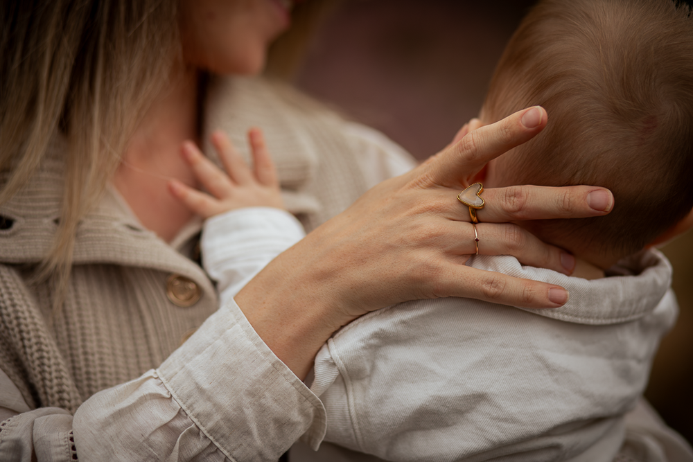 Close-up van een moeder die haar baby liefdevol tegen zich aanhoudt.