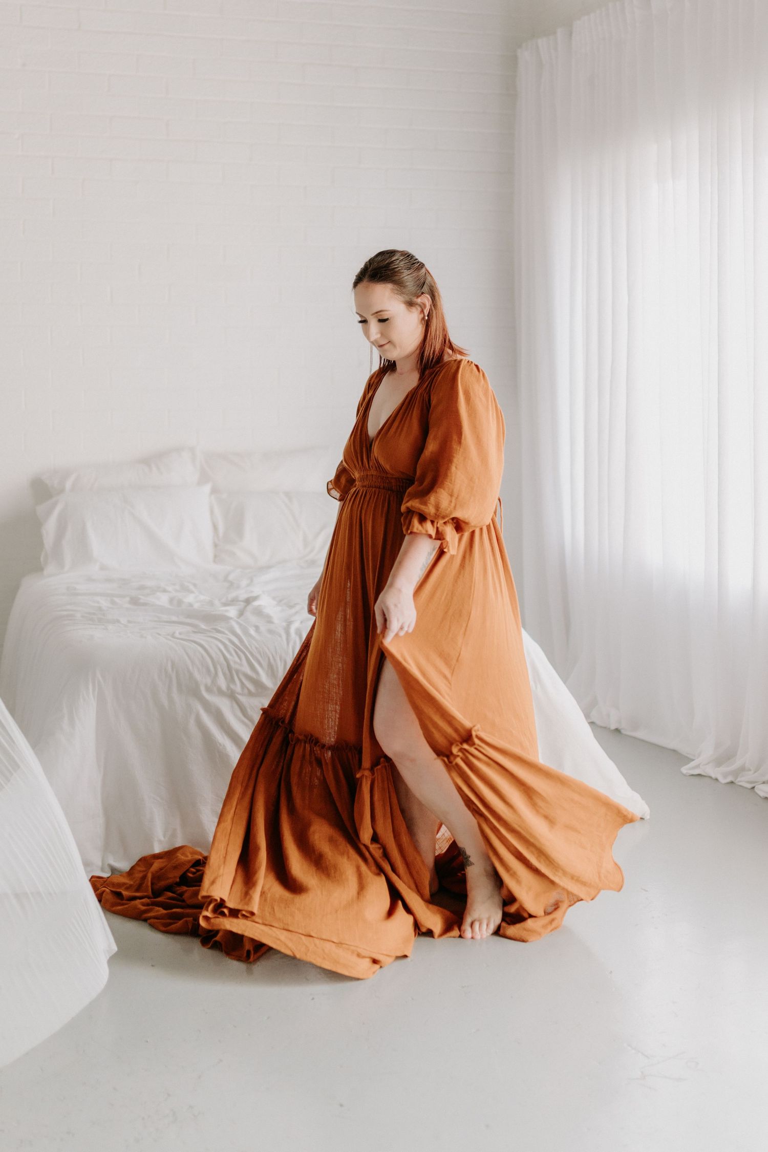 Elegant brown chiffon gown with long flowing sleeves, plunging neckline, empire waist and dramatic long train on mannequin.