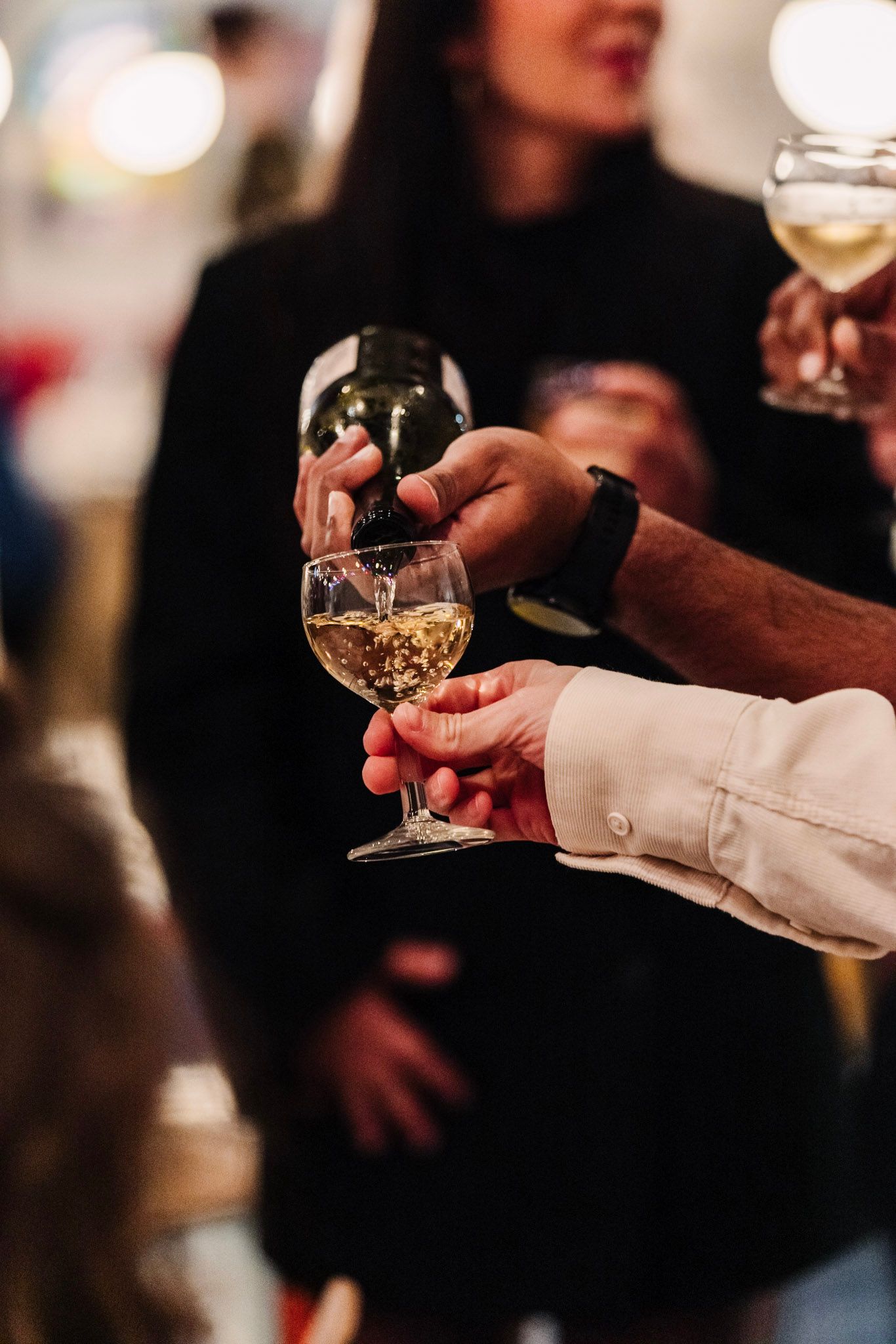Hands holding wine glasses in anticipation of the wedding toast.