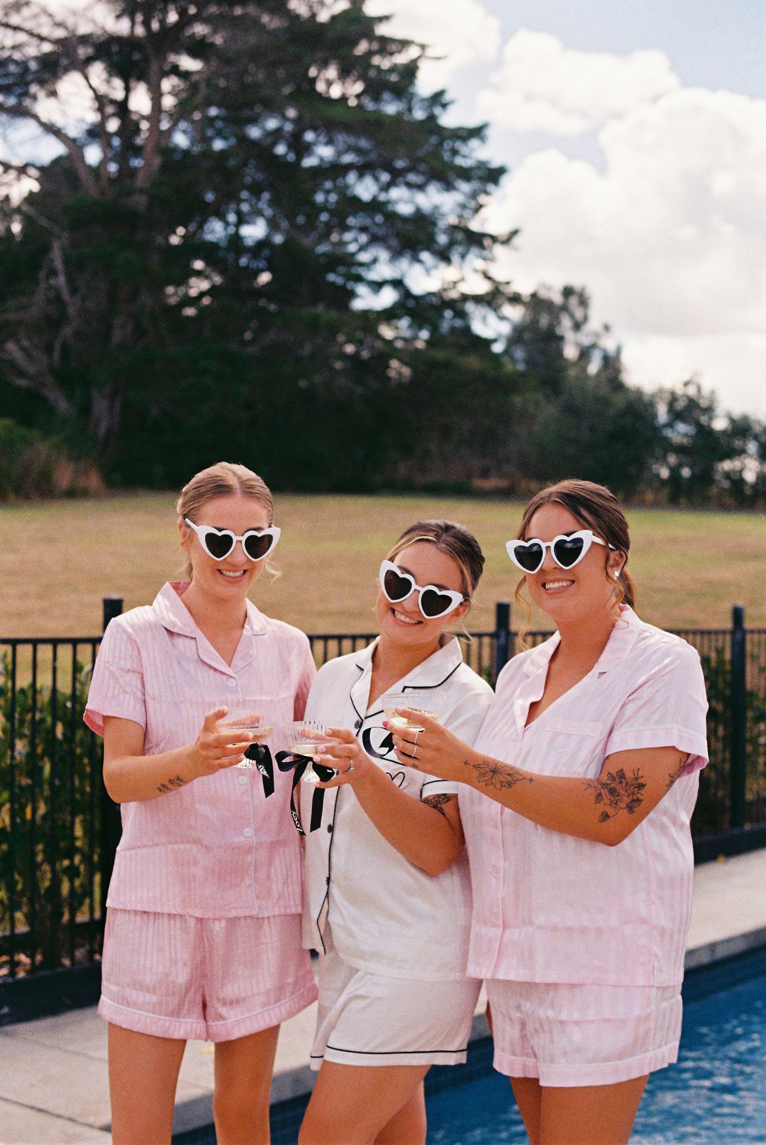 Bride and bridesmaids posing with champagne at Auckland wedding