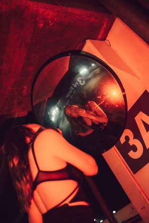Abstract artistic composition with red lighting and reflective surfaces creating a dramatic mood.