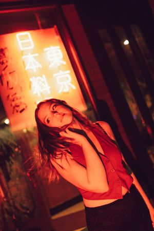 Dramatic red-lit silhouettes against illuminated Chinese characters in a nighttime setting.